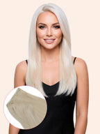 Woman with long blonde hair extensions on a beige background